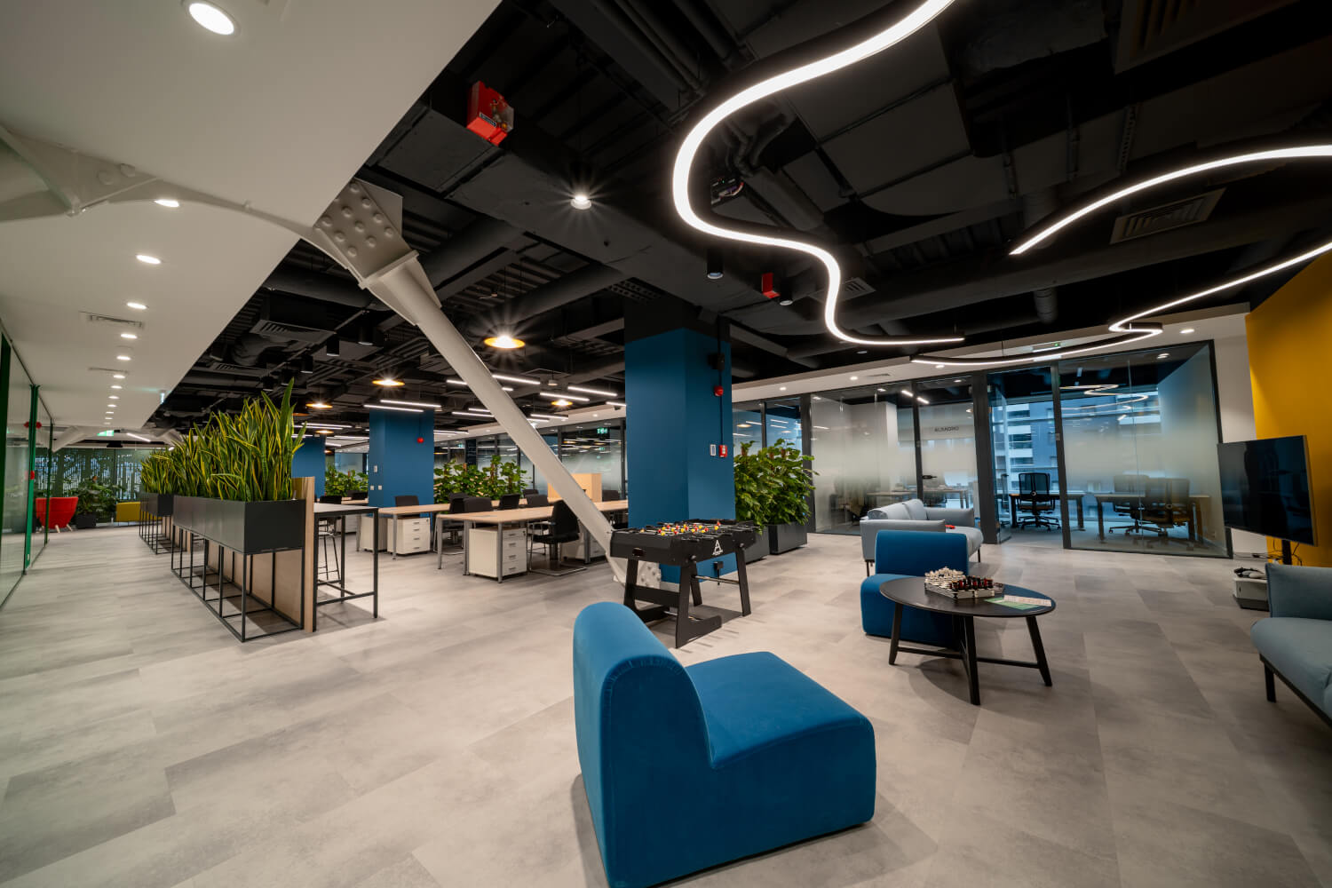 Modern lounge area with blue chairs and foosball table